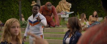 Movie still from “Me Time” (2022), directed by John Hamburg – A man and a woman standing in front of a statue of a gorilla; Medium shot, Over the shoulder angle