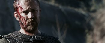 Movie still from “Medieval” (2022), directed by Petr Jákl – A person with a beard wearing armor; Close Up shot, Low angle