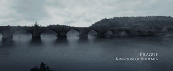 Movie still from “Medieval” (2022), directed by Petr Jákl – A bridge that is in the middle of a river; Extreme Wide shot, High angle