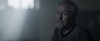 Movie still from “Medieval” (2022), directed by Petr Jákl – An older man with a beard and mustache; Close Up shot, Over the shoulder angle