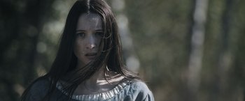 Movie still from “Medieval” (2022), directed by Petr Jákl – A woman with long dark brown hair wearing a blue dress; Close Up shot, Over the shoulder angle