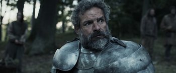 Movie still from “Medieval” (2022), directed by Petr Jákl – A person wearing a suit of armor; Close Up shot, Low angle