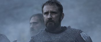 Movie still from “Medieval” (2022), directed by Petr Jákl – A person wearing a chain mail armor; Close Up shot, Low angle