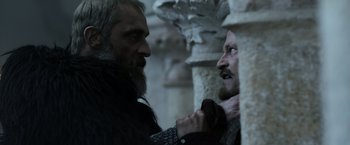 Movie still from “Medieval” (2022), directed by Petr Jákl – Two men in medieval garb are facing each other; Close Up shot, Low angle