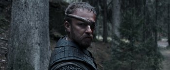 Movie still from “Medieval” (2022), directed by Petr Jákl – A person wearing armor; Close Up shot, Over the shoulder angle