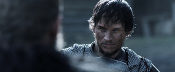 Movie still from “Medieval” (2022), directed by Petr Jákl – A person wearing a chain mail armor; Close Up shot, Over the shoulder angle