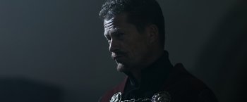 Movie still from “Medieval” (2022), directed by Petr Jákl – A person wearing a suit and tie; Close Up shot, Low angle