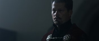 Movie still from “Medieval” (2022), directed by Petr Jákl – A person wearing a chain around their neck; Close Up shot, Low angle