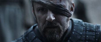 Movie still from “Medieval” (2022), directed by Petr Jákl – A person with a beard and a blindfold; Close Up shot, Low angle