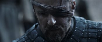 Movie still from “Medieval” (2022), directed by Petr Jákl – A person with a bandage on his head; Close Up shot, Over the shoulder angle