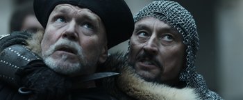 Movie still from “Medieval” (2022), directed by Petr Jákl – Two men in medieval garb looking at the camera; Close Up shot, Low angle