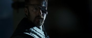 Movie still from “Medieval” (2022), directed by Petr Jákl – A person wearing a helmet and glasses; Close Up shot, Over the shoulder angle