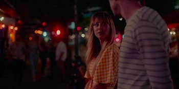 Movie still from “Meet Cute” (2022), directed by Alex Lehmann – A woman in an orange checkered shirt standing next to a man; Medium shot, Over the shoulder angle