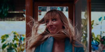 Movie still from “Meet Cute” (2022), directed by Alex Lehmann – A person with long blonde hair; Close Up shot, Low angle