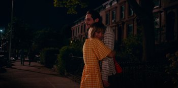 Movie still from “Meet Cute” (2022), directed by Alex Lehmann – A man and a woman hugging on a sidewalk; Medium shot, High angle