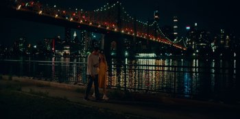 Movie still from “Meet Cute” (2022), directed by Alex Lehmann – A man and a woman standing next to each other near a bridge; Extreme Wide shot, High angle