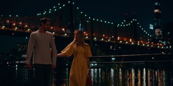 Movie still from “Meet Cute” (2022), directed by Alex Lehmann – A man and a woman holding hands while standing on a bridge; Medium shot, Low angle