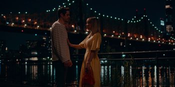 Movie still from “Meet Cute” (2022), directed by Alex Lehmann – A man and a woman standing next to each other on a bridge at night; Medium shot, High angle