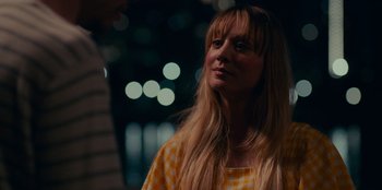 Movie still from “Meet Cute” (2022), directed by Alex Lehmann – A woman with long blonde hair wearing a checkered shirt; Close Up shot, Over the shoulder angle
