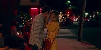 Movie still from “Meet Cute” (2022), directed by Alex Lehmann – A man and a woman kissing on the side of the street; Medium shot, Over the shoulder angle