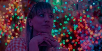 Movie still from “Meet Cute” (2022), directed by Alex Lehmann – A woman with her hands under her chin looking up; Close Up shot, Low angle