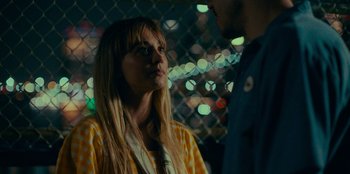 Movie still from “Meet Cute” (2022), directed by Alex Lehmann – A woman and a man standing next to each other in front of a fence; Close Up shot, Over the shoulder angle