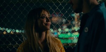 Movie still from “Meet Cute” (2022), directed by Alex Lehmann – A woman is looking at a man in the dark; Close Up shot, Over the shoulder angle