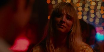Movie still from “Meet Cute” (2022), directed by Alex Lehmann – A woman with blond hair and a long fringe; Close Up shot, Over the shoulder angle