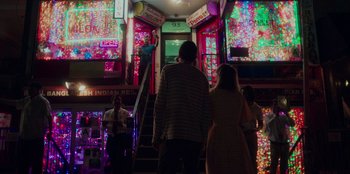 Movie still from “Meet Cute” (2022), directed by Alex Lehmann – A man and a woman walking down a set of stairs; Extreme Wide shot, High angle
