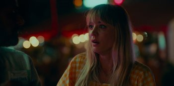 Movie still from “Meet Cute” (2022), directed by Alex Lehmann – A woman with blonde hair and a checkered shirt; Close Up shot, Over the shoulder angle
