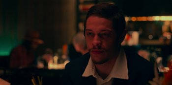 Movie still from “Meet Cute” (2022), directed by Alex Lehmann – A person wearing a suit and tie; Close Up shot, Over the shoulder angle