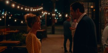 Movie still from “Meet Cute” (2022), directed by Alex Lehmann – A man and a woman are talking in the dark; Medium shot, Over the shoulder angle