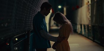 Movie still from “Meet Cute” (2022), directed by Alex Lehmann – A man and a woman holding hands in the dark; Medium shot, Over the shoulder angle
