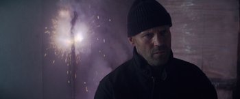 Movie still from “Meg 2: The Trench” (2023), directed by Ben Wheatley – A man wearing a black jacket and a black hat; Close Up shot, Low angle