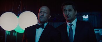 Movie still from “Meg 2: The Trench” (2023), directed by Ben Wheatley – A couple of men standing next to each other in a room; Medium shot, Low angle