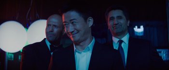 Movie still from “Meg 2: The Trench” (2023), directed by Ben Wheatley – A group of men standing next to each other in suits; Close Up shot, Low angle