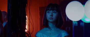 Movie still from “Meg 2: The Trench” (2023), directed by Ben Wheatley – A young woman with short black hair is standing in front of a window; Close Up shot, Low angle