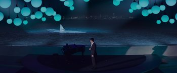 Movie still from “Meg 2: The Trench” (2023), directed by Ben Wheatley – A man standing in front of an ocean with a piano; Extreme Wide shot, High angle