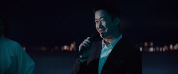 Movie still from “Meg 2: The Trench” (2023), directed by Ben Wheatley – A man holding a microphone in his hand; Medium shot, Over the shoulder angle