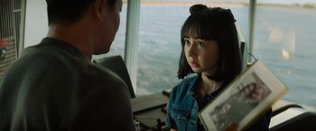 Movie still from “Meg 2: The Trench” (2023), directed by Ben Wheatley – A woman in a denim jacket is talking to a man in front of a window; Close Up shot, Over the shoulder angle