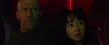 Movie still from “Meg 2: The Trench” (2023), directed by Ben Wheatley – A man and a woman sitting in the back of a car; Close Up shot, Over the shoulder angle