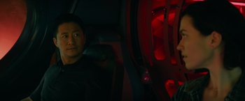Movie still from “Meg 2: The Trench” (2023), directed by Ben Wheatley – A man sitting in the back seat of a vehicle; Medium shot, High angle