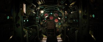 Movie still from “Meg 2: The Trench” (2023), directed by Ben Wheatley – The inside of a fighter jet cockpit with lights on; Wide shot, Overhead angle