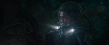 Movie still from “Meg 2: The Trench” (2023), directed by Ben Wheatley – A man wearing a space suit and a helmet; Medium shot, Over the shoulder angle
