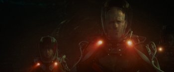 Movie still from “Meg 2: The Trench” (2023), directed by Ben Wheatley – A man and a woman in a space suit with lights on them; Medium shot, Low angle