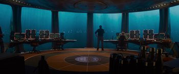 Movie still from “Meg 2: The Trench” (2023), directed by Ben Wheatley – A man standing in front of a window in a room; Extreme Wide shot, Over the shoulder angle