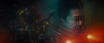 Movie still from “Meg 2: The Trench” (2023), directed by Ben Wheatley – A man in a space suit in the dark; Close Up shot, Over the shoulder angle