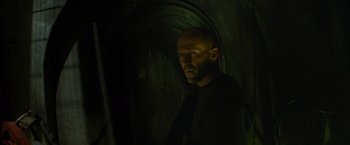 Movie still from “Meg 2: The Trench” (2023), directed by Ben Wheatley – A man with a bald head standing in a dark tunnel; Close Up shot, Low angle