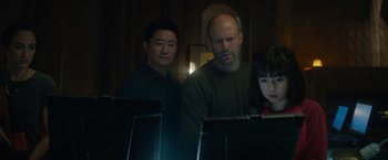 Movie still from “Meg 2: The Trench” (2023), directed by Ben Wheatley – Two men and a woman looking at a computer screen; Medium shot, Low angle