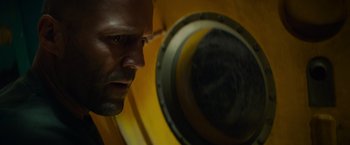 Movie still from “Meg 2: The Trench” (2023), directed by Ben Wheatley – A man's face as he looks into a mirror; Close Up shot, Over the shoulder angle